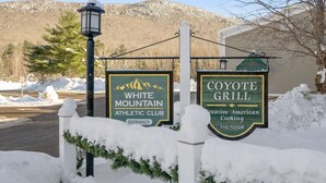 Skyltar för White Mountain Athletic Club och Coyote Grill, som visar var ingången och restaurangen finns.