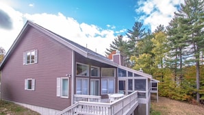 A two-story house with a deck and a covered porch. - Playful Nest (North Conway)