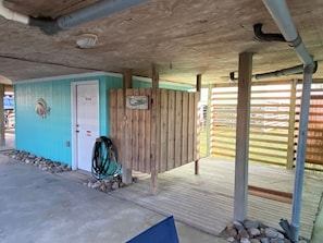 Ein überdachter Außenbereich mit Holzterrasse, einer Tür und einer Wand mit Fischdekor.