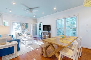 Relax in this spacious living area with a dining table for four, flat-screen TV, and comfortable sofa.