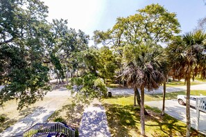 Stroll through a serene neighborhood surrounded by lush trees and a beautifully manicured lawn.