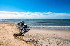 Enjoy a serene beach experience with access to the ocean and a natural rock formation.
