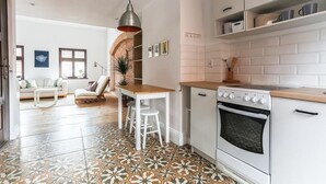 A modern kitchen with white cabinets, a wooden countertop, and a patterned tile floor. - Bonjour Apartment - Old Town Mostowa  - Central Location (Toruń)