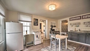 A kitchen with a refrigerator, stove, sink, and a dining area with a table and chairs. - Romantic Country Apt by Lake Erie & Wineries! (Westfield)