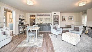 A modern kitchen with a dining area, featuring a white stove, a coffee station, and a sign indicating the location as Times Square. - Romantic Country Apt by Lake Erie & Wineries! (Westfield)