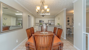 A dining area with a wooden table and chairs, a chandelier, and a kitchen in the background. - Welcoming Woodmere Wonder, WiFi, Pool & Parking (Montgomery)