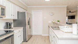 A modern kitchen with white cabinets, stainless steel appliances, and a white countertop. - Welcoming Woodmere Wonder, WiFi, Pool & Parking (Montgomery)