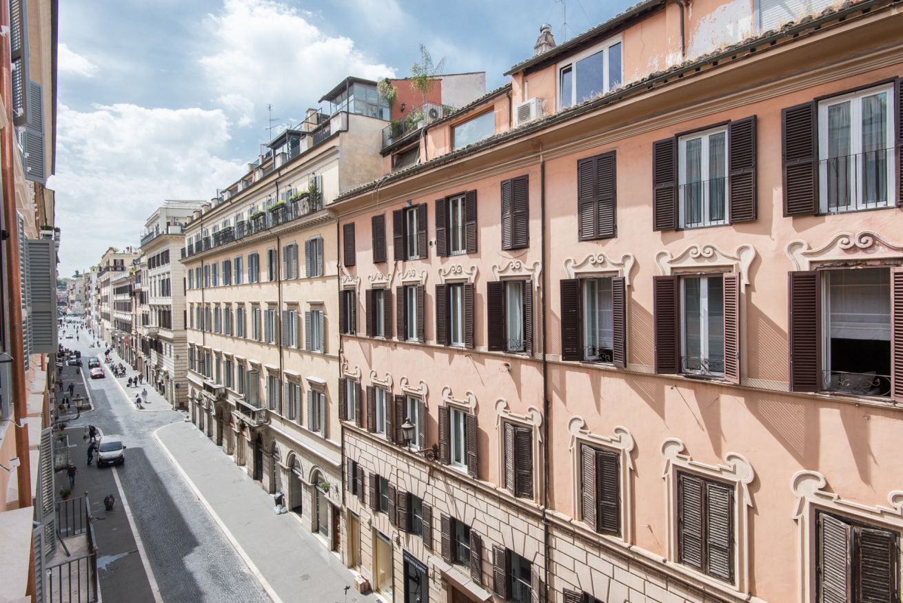 A row of multi-story buildings with uniform architectural style, featuring balconies and large windows.