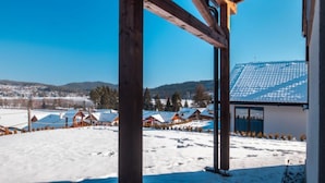 Paisaje nevado con construcciones de madera y cielo azul despejado.