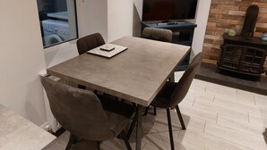 Comedor con mesa, sillas, televisor y chimenea.