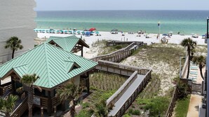 A beach view with a wooden boardwalk, beach umbrellas, and a sandy beach. - 🦩Book Me Baby! Gulf View ~ It's The Treasure You Have Been looking For!🦩 (Fort Walton Beach)