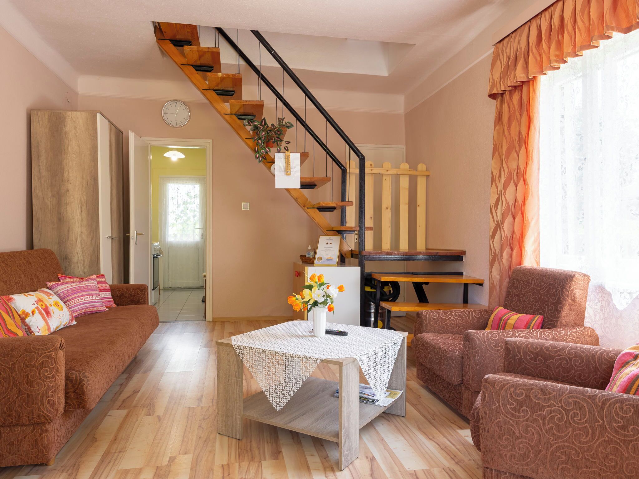 Ein Wohnzimmer mit Treppe, zwei Sofas, einem Couchtisch und einem Esstisch.