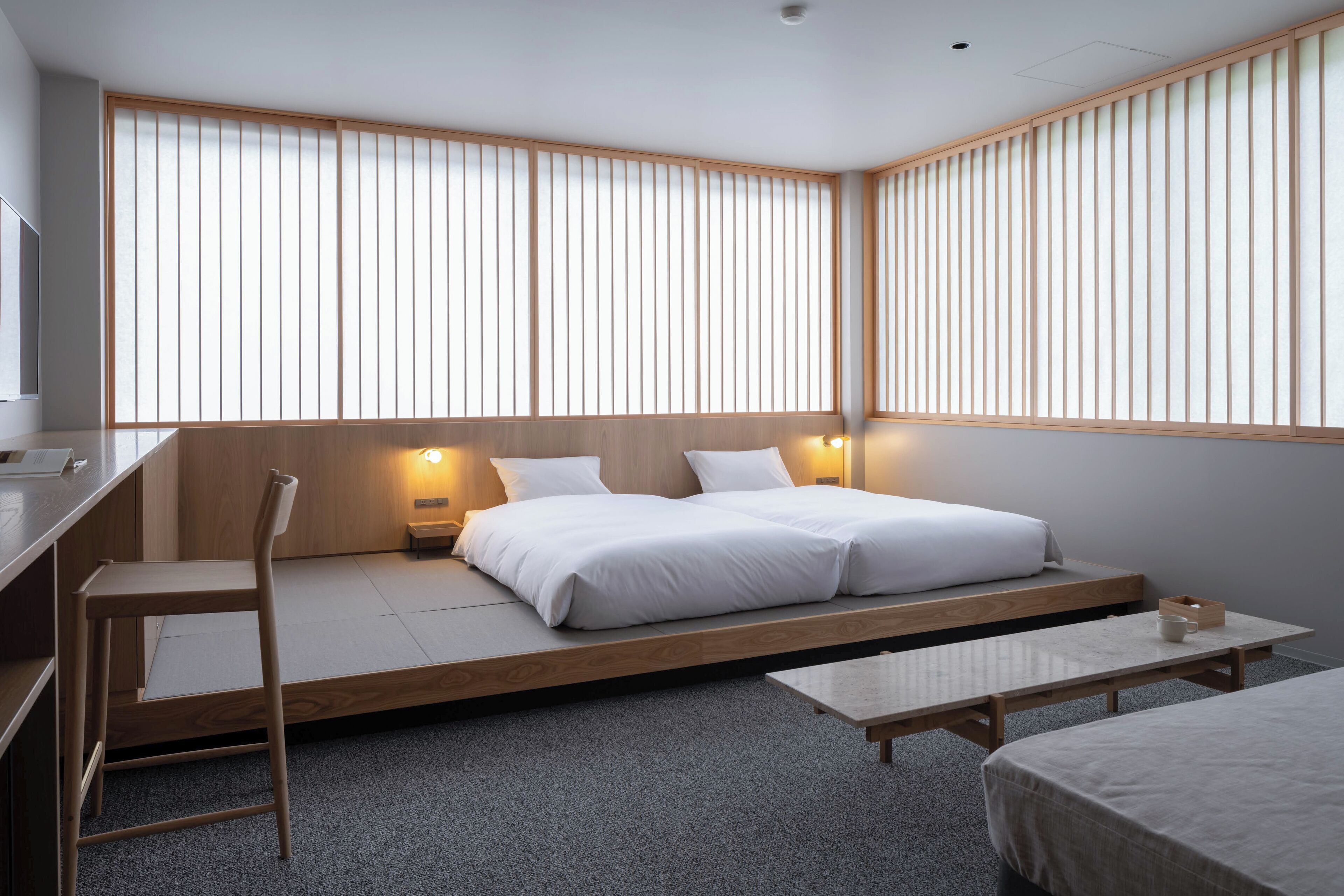 A modern room with a bed, a desk, and a chair.