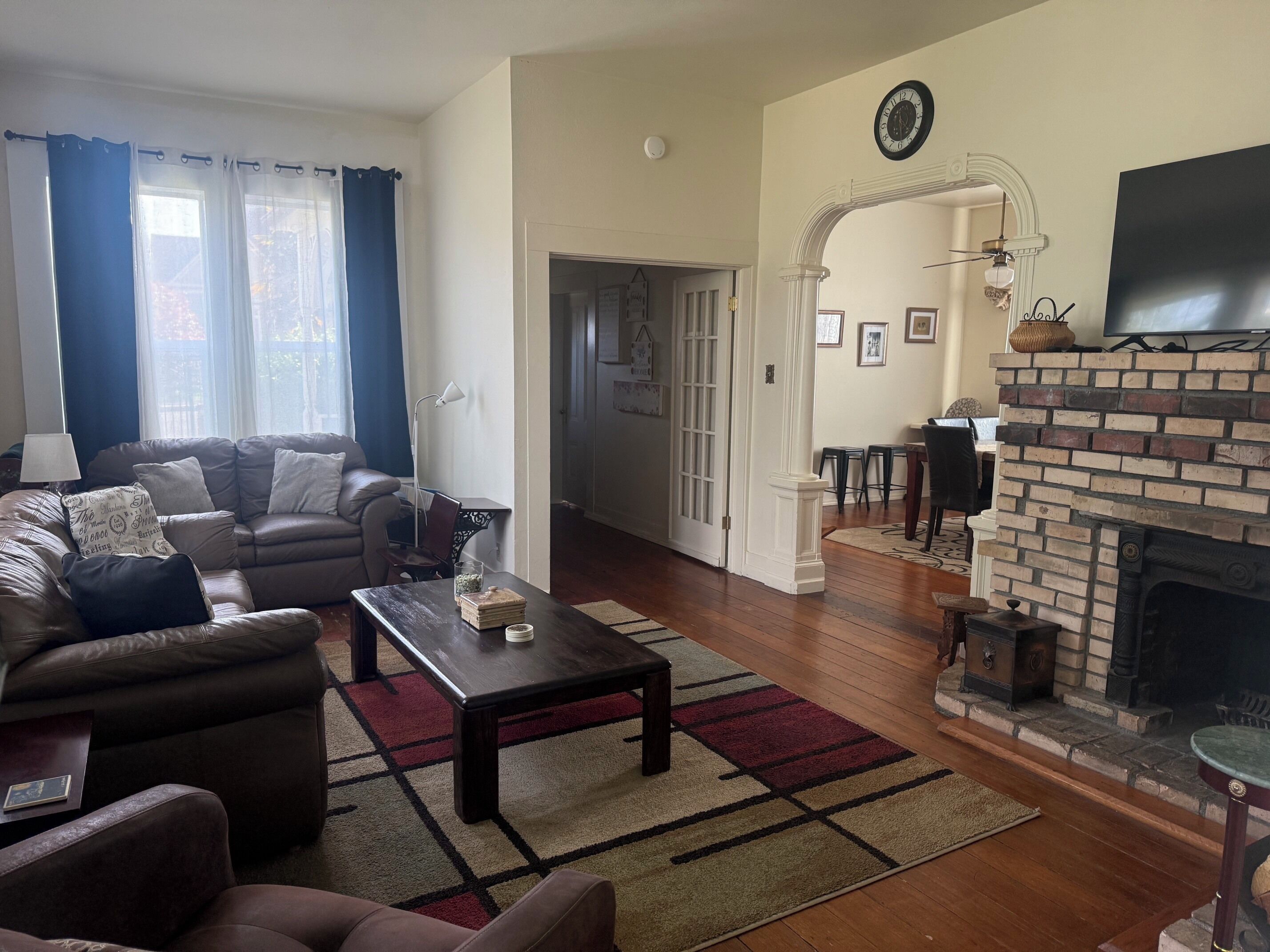 A living room with a sofa, coffee table, fireplace, and a television.