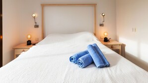 A neatly made bed with white bedding and two rolled towels on the side. - Adelfa 7 by Interhome (L'Escala)
