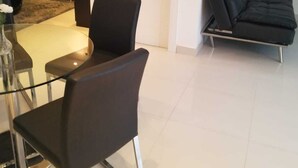 A modern living room with a black sofa, a glass coffee table, and a black chair. - The White House in Gulabo (Santiago de los Caballeros)