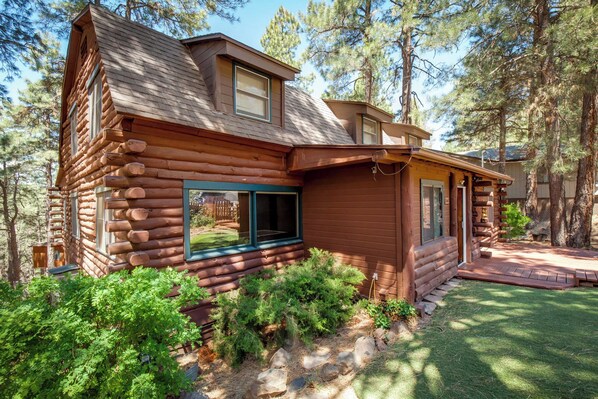 A log cabin with a large window, surrounded by dense forest. - Stunning large Cabin with AC, Pool table, fenced yard (Flagstaff)