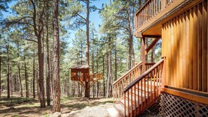 A wooden cabin with a staircase and a lookout tower in a forest. - Stunning large Cabin with AC, Pool table, fenced yard (Flagstaff)