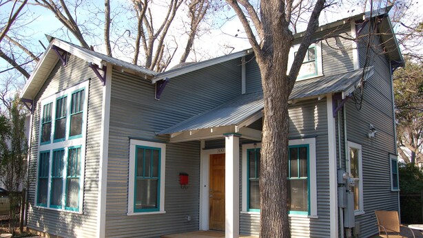 A two-story house with a porch, a front door, and a mailbox. - Modern Craftsman Style House in Hyde Park, Austin (Austin)