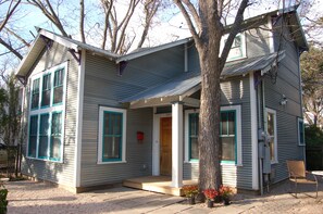 A two-story house with a porch, a front door, and a mailbox.