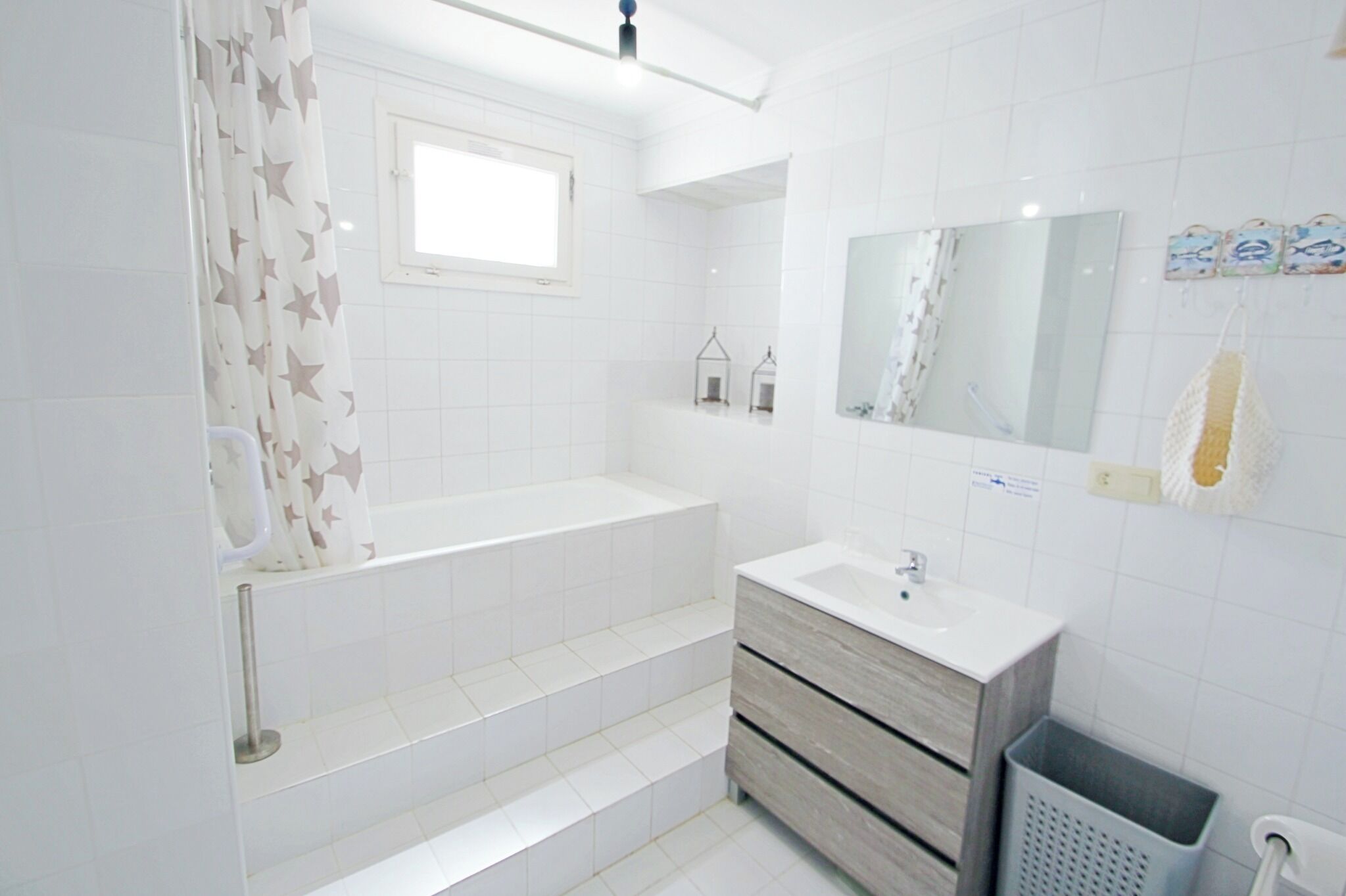 A modern bathroom with a bathtub, a sink, and a vanity.