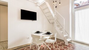 A modern interior with a dining area, a flat-screen TV, a staircase, and a large window. - Apartment "Bellagio amorevole dimora in Lecco" with Air Conditioning (Lecco)