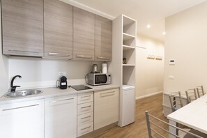 Una cucina moderna con forno a microonde integrato, macchina da caffè e lavello.