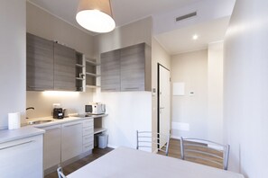 Una cocina moderna con electrodomésticos integrados, una mesa de comedor y una silla.