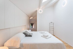 Et moderne hotelværelse med seng, vindue og ovenlys.