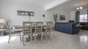 A dining area with a round table and chairs, a sofa, and a television in a living room. - Villa Casa Rosina close to Beach with Pool & Wi-Fi (Ferragudo)