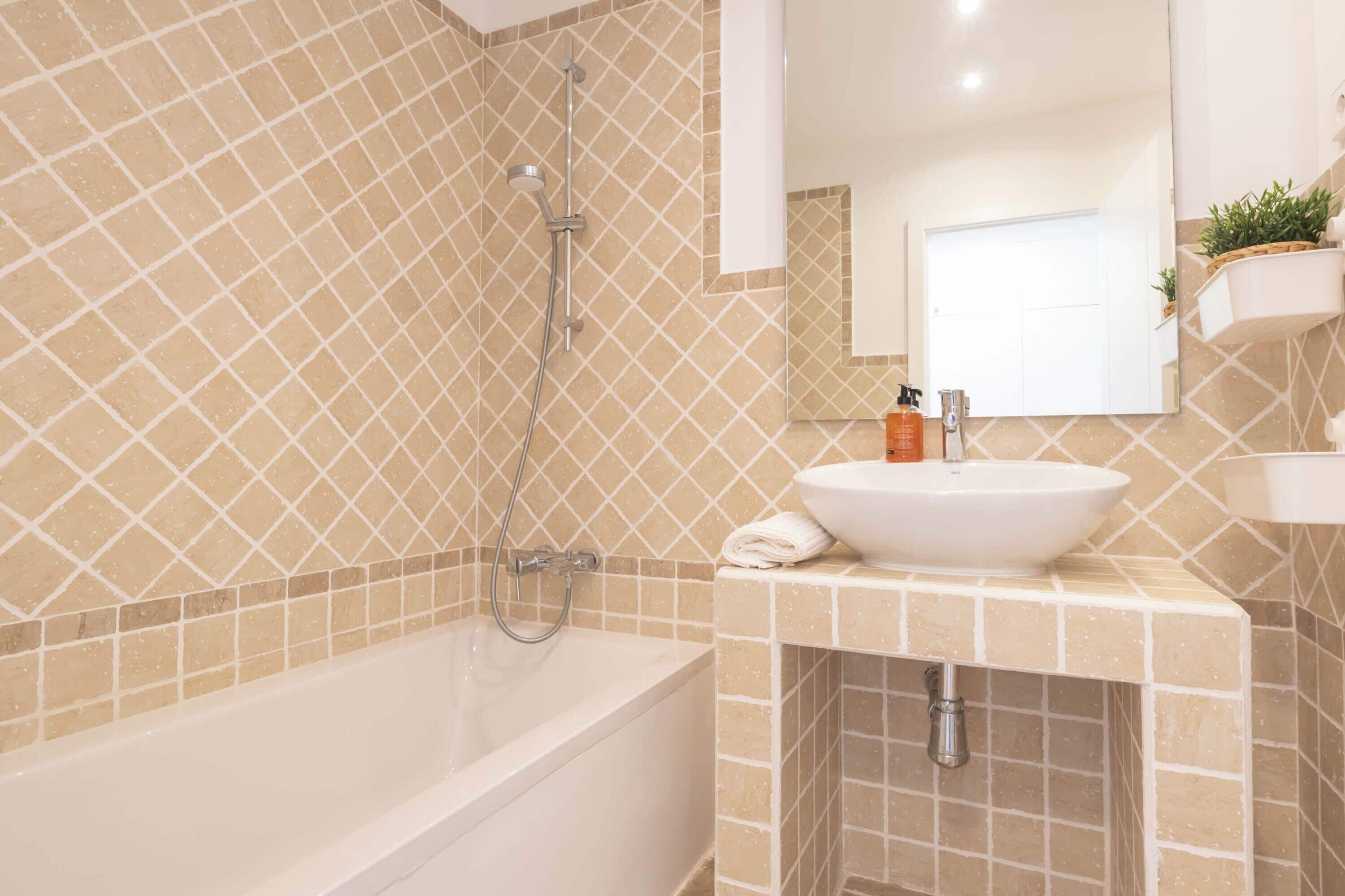Een badkamer met een bad, wastafel en douche.