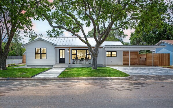 A single-story house with a front porch, a garage, and a well-maintained lawn.
