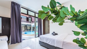 Een moderne hotelkamer met een groot bed, uitzicht op een zwembad en een balkon.