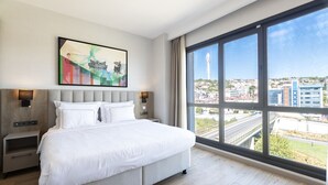 A modern hotel room with a large bed, a city view, and a painting on the wall. -  Antwell Suites (Istanbul)