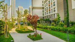 A modern urban residential area with high-rise buildings, a well-maintained garden with a pathway, and a clear sky. -  Antwell Suites (Istanbul)