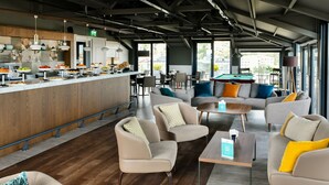 A modern lounge area with sofas, a pool table, and a buffet with various food items. -  Antwell Suites (Istanbul)