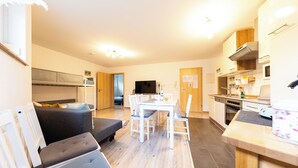 A modern apartment with a dining area, kitchen, and living space.
