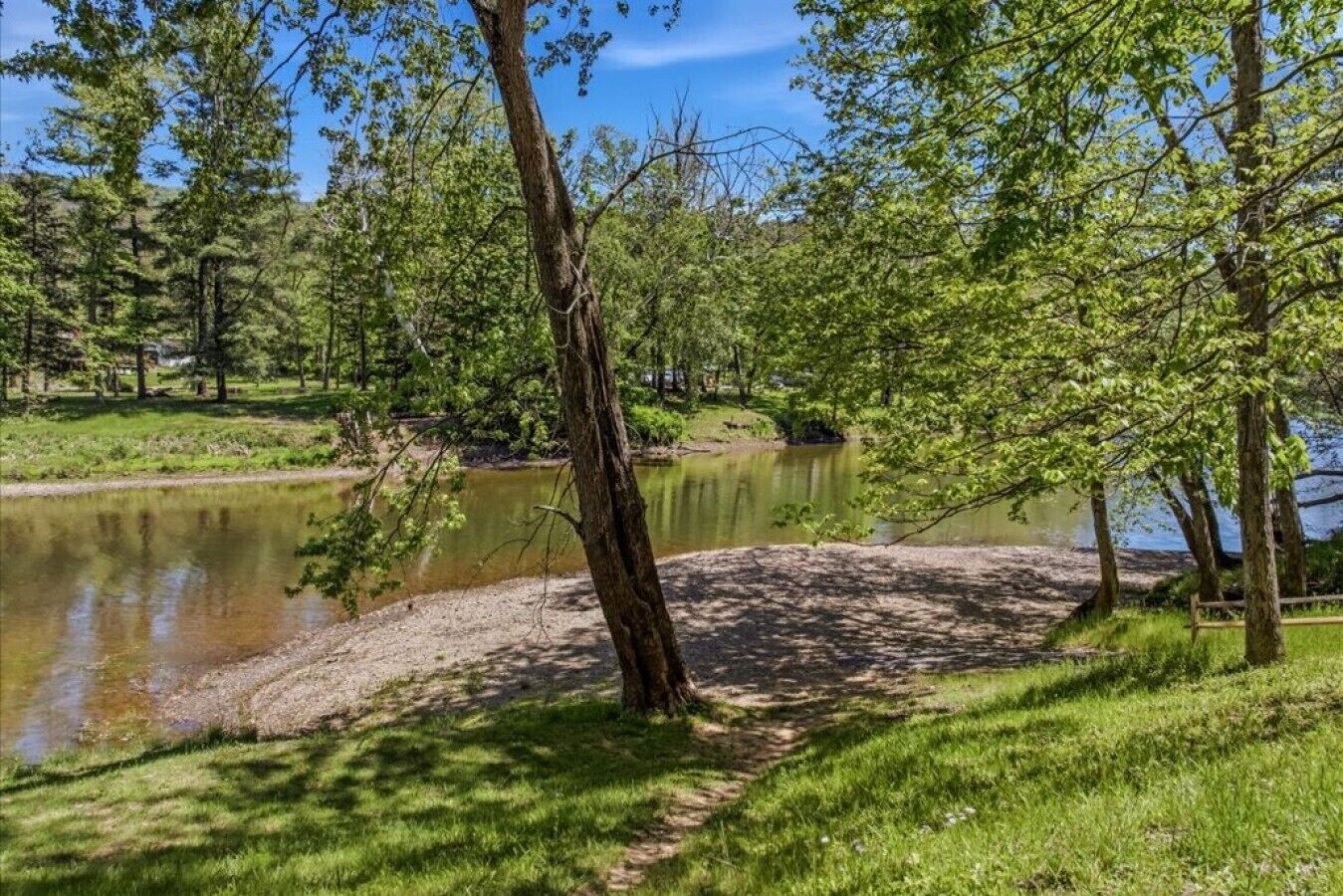 Un paysage naturel comprenant un étang, des arbres et une zone herbeuse.