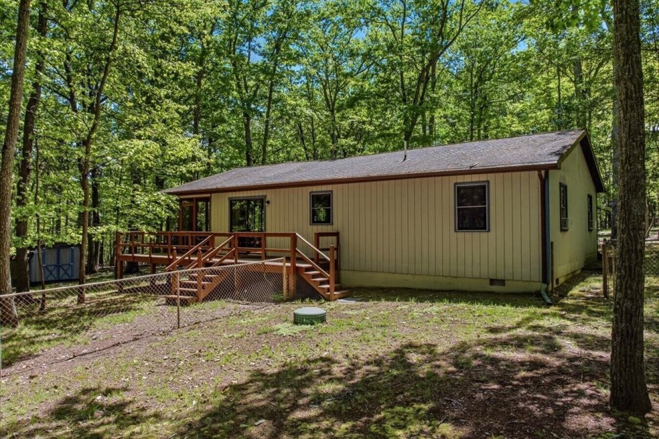 Une cabane de plain-pied dotée d’une terrasse en bois et d’un escalier menant à l’entrée.