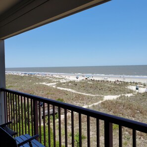 A beach view from a balcony with a railing, sandy beach, and dunes. - Panoramic view, hear the sounds, feel the moods of the beach. No price increase. (Hilton Head Island)