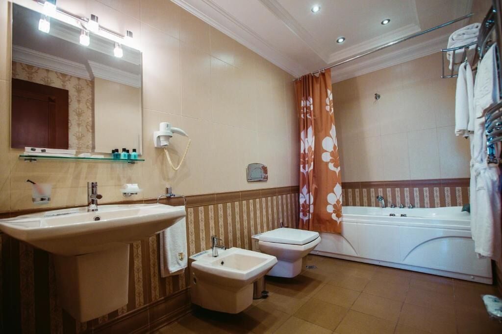 Un baño con un lavabo grande, un bidé, un inodoro y una bañera.