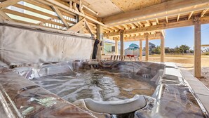 A hot tub under a wooden pergola with a view of houses in the background. - 6129 Lady Jane * Semi-Oceanfront * Hot Tub (Nags Head)