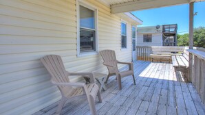 A wooden deck with two Adirondack chairs, a small table, and a wooden railing. - High Five: Classic OBX Escape Near the Beach (Kill Devil Hills)