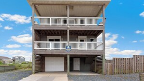 A two-story building with a garage and a balcony on the upper floor. - The Shake Shack: Dog-Friendly + 450ft to Beach (Kitty Hawk)