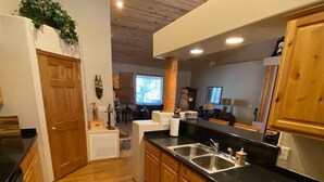 A kitchen with wooden cabinets, a black countertop, stainless steel appliances, and a wooden floor. - Great Cabin in Torreon Community of Show Low (Show Low)
