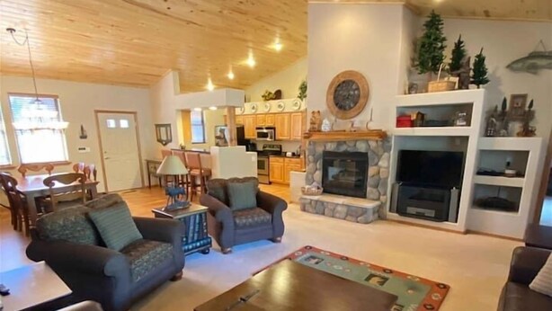 A spacious living room with a fireplace, a ceiling fan, and a dining area in the background. - Great Cabin in Torreon Community of Show Low (Show Low)