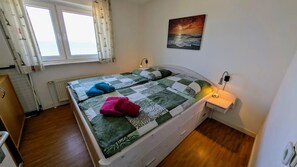 Gemütliches Schlafzimmer mit Doppelbett und großem Fenster