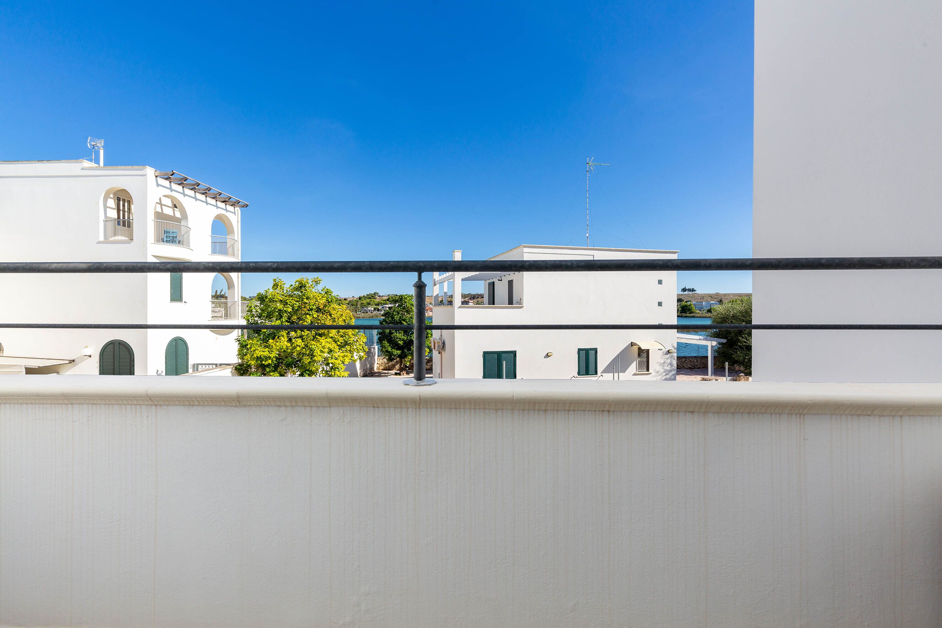 A white building with arched windows and a balcony.