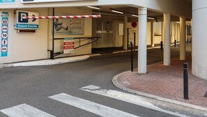 A parking entrance with a barrier gate, a sign for 'Suquet Forville', and a pedestrian crossing.