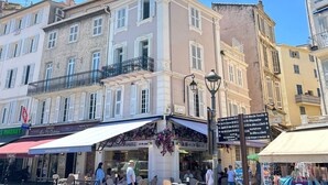 A street scene with a bakery, a pharmacy, and a market.